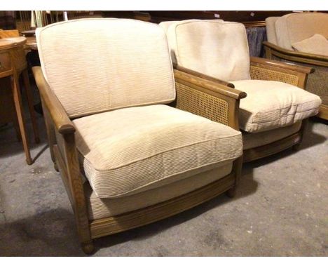 A lady and gentleman's Ercol armchair set, both with caned sides and sand corduroy upholstery, both stamped Ercol, on turned 
