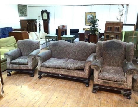 A 1920s/30s suite including a two seater sofa and lady's and gentleman's armchairs, all with scroll arms with blind fretwork 