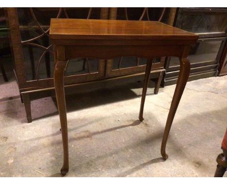 An Edwardian mahogany card table, the rectangular top with boxwood and ebony strung border, opening to a baize lined interior