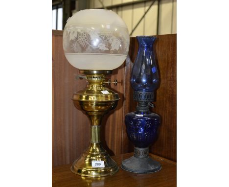A brass oil lamp, reeded column, etched globular shade; another, blue glass (2)