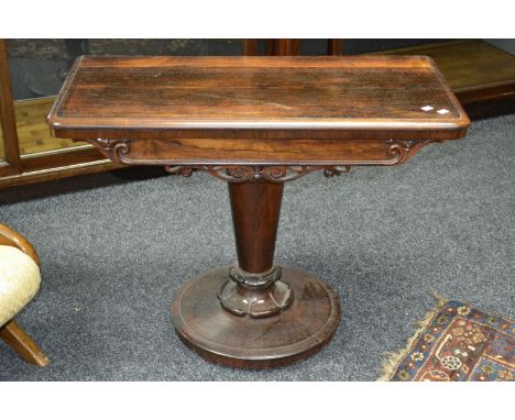 A Victorian rosewood card table, fold over top opening to green baize playing area, frieze decorated with carved swags and cu