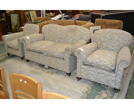 A three piece suite comprising two seat drop arm sofa and two armchairs, circa 1900 (3)