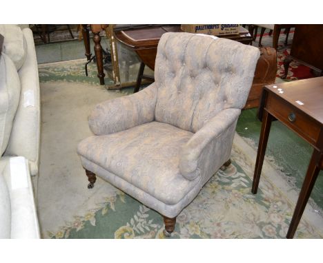An early 20th century button back fireside chair.