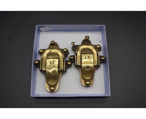 A pair of Louis Vuitton brass trunk clasps, late 19th century, each with six rivets, 10.5 x 7.5cm.&nbsp; 