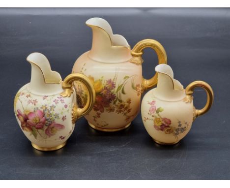 A graduated set of three royal Worcester blush ivory ewers, shape no. 1094, largest 15.5cm high. (3) 