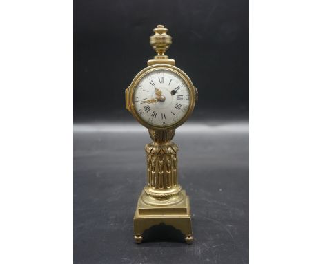 An antique Continental brass pillar timepiece, with 2 1/4in enamel dial, 23cm high, (with later battery operated movement).&n
