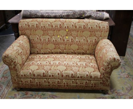 A SMALL UPHOLSTERED DROP ARM SOFA W 143 CM