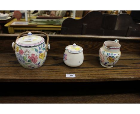 A Poole pottery biscuit barrel; a preserve pot and cream jug