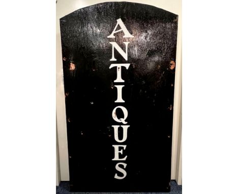A vintage painted wooden 'Antiques' shop sign - black with vertical 'old style' white lettering, arched top, drilled for moun