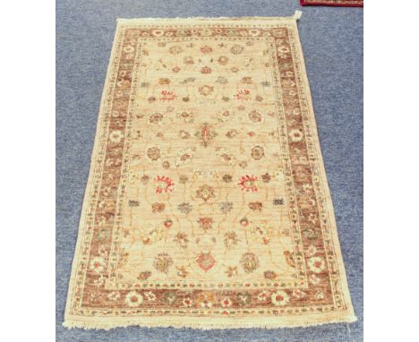 A small Zeigler wool rug - with floral decoration on a buff field, within a light brown floral border and ivory guards, 155 x