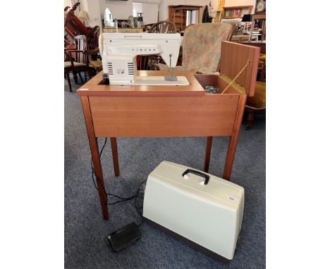 A vintage 1970s Singer 368 Fashion Mate electric sewing machine - fitted into a teak table cabinet, with separate plastic car