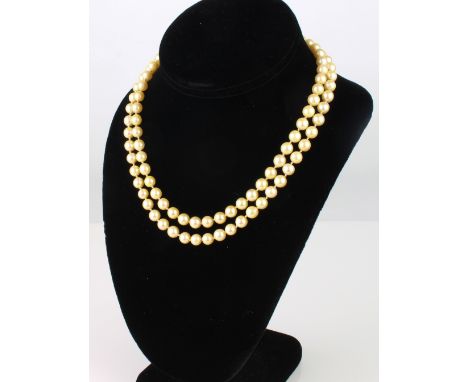 A vintage two strand cultured pearl necklace - mid-20th century, with golden toned 6mm pearls and foliate chased 9ct yellow g