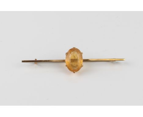 A vintage 9ct gold and citrine bar brooch - stamped '9CT', with an oval cut 14 x 9mm citrine, 57mm long.