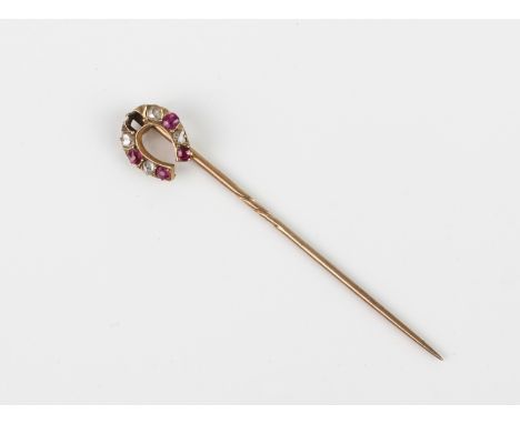 An antique 9ct yellow gold, ruby and diamond horseshoe stick pin - with rose gold pin, one ruby missing, 5.4 cm long.