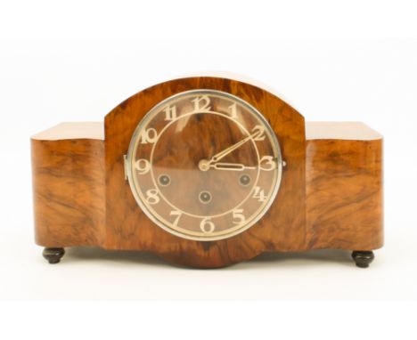 An Art Deco walnut-cased mantel clock - 1940s-50s, the serpentine, broken-arch case with Arabic, silvered skeletonised chapte