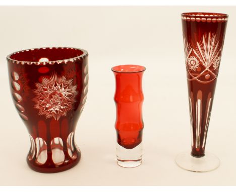 Three pieces of coloured glass - comprising a Bohemian ruby cased vase, 17.3 cm high; a Bohemian ruby cased trumpet vase; and