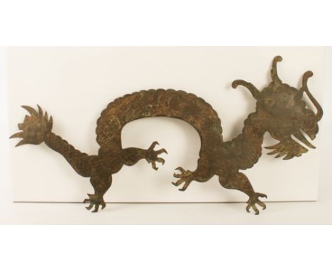 A Chinese bronze dragon plaque - probably 19th century, the long bodied, four-toed dragon with engraved detail and diaper wor