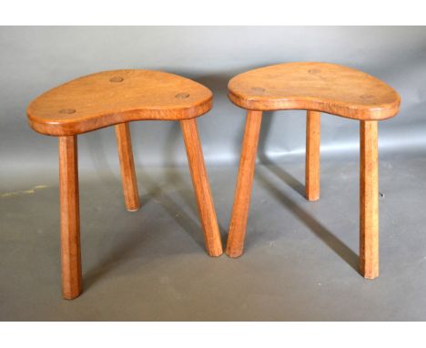 Robert (Mouseman) Thompson, A Pair of Oak Stools of Kidney Form, each raised upon tapering octagonal legs and carved with the