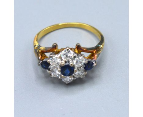 A 9ct. Yellow Gold Diamond And Sapphire Cluster Ring set with six central sapphires surrounded by diamonds and with sapphire 