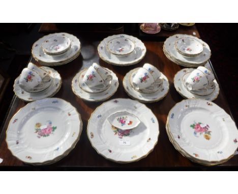 A DRESDEN DINNER SERVICE of traditional design, with central floral sprays within a gilt border and matching teaware (complet