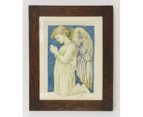 Della Robbia Pottery, a plaque of a praying angel, in low relief with a circle-punched blue background, within a canted 'fram