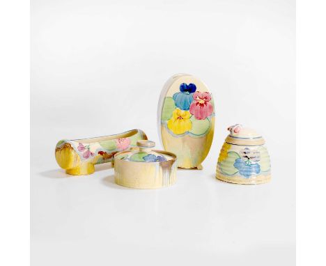 Clarice Cliff (1899-1972), a group of 'Delecia Pansies' pottery items, c.1930, comprising a Beehive honey pot and cover, a po