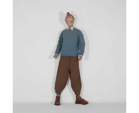 Tintin, a figure of Tintin, 20th century, modelled smiling, wearing a blue jumper, white shirt and plus fours, socks and walk