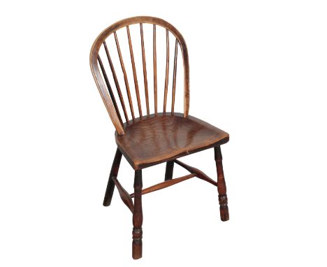 A GEORGE II PRIMITIVE WINDSOR CHAIR with a hooped comb back above an elm saddle seat, on four turned legs joined by stretcher