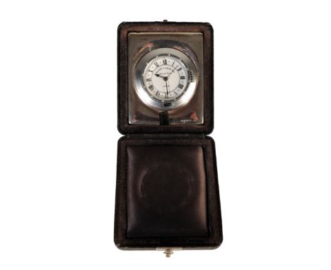 A SILVER CASED TRAVELLING CLOCK, the dial inscribed " Roger Lascelles London", with quartz alarm movement, 8.5cm x 7cm, in a 