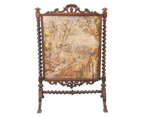 A VICTORIAN WALNUT FIRESCREEN 19th century, the carved cresting rail above an embroidered panel, with turned twisted supports