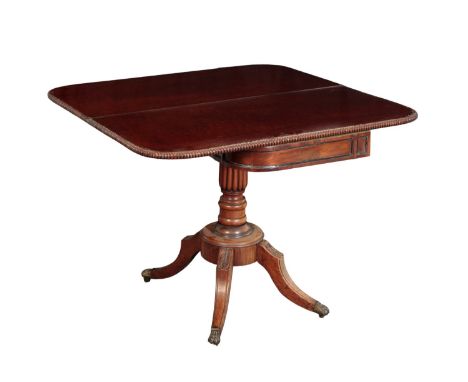 A REGENCY MAHOGANY TEA TABLE the hinged top with a gadrooned edge, on a turned column to quatreform base, 78cm high x 100cm w