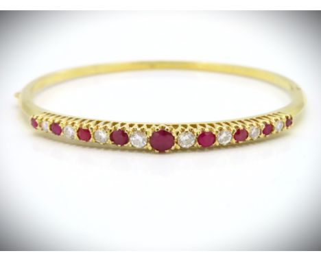 An 18ct gold bangle set with ruby & diamond, centre ruby measures 5mm wide & diamonds approx. 0.94ct, 15.4g