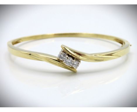 A 14ct gold bangle set with three diamonds of approx. 0.5ct, 58mm x 47mm internal measurement, 14g