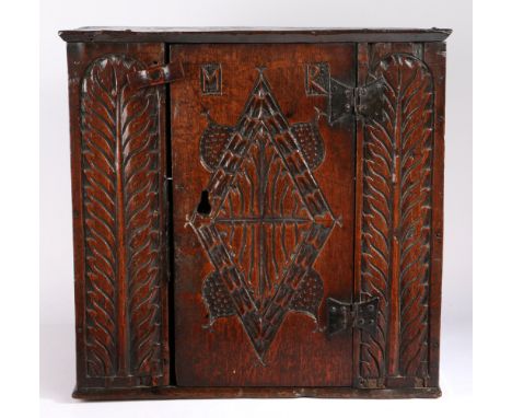 A rare Charles I oak boarded mural cupboard, Gloucestershire/Welsh Borders, circa 1630  The top with chamfered under edge, th