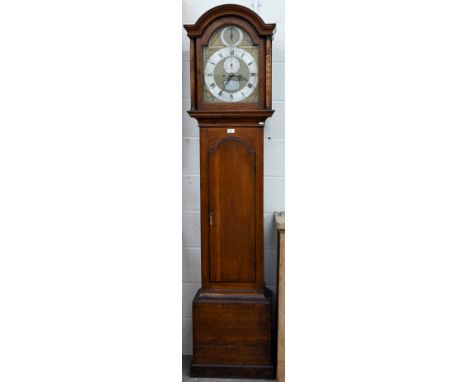 An early 19th century oak longcase clock, the eight day movement with arched brass and silvered dial, by Richard Dennett of N