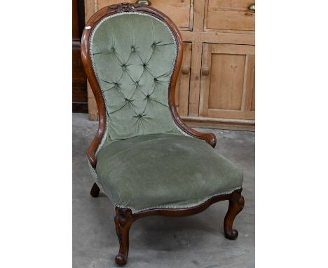A Victorian carved mahogany nursing chair with green dralon button back upholstery 