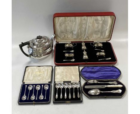 A silver cruet set, cased, a silver teapot, two sets of six silver teaspoons, cased and a silver christening flatware set, ca