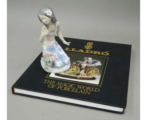 A Lladro porcelain figurine of a young girl and a Lladro book