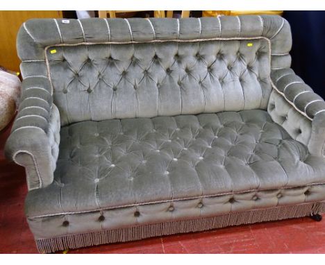 Neat button upholstered two seater salon couch on ebonized supports and black pot castors, circa 1910