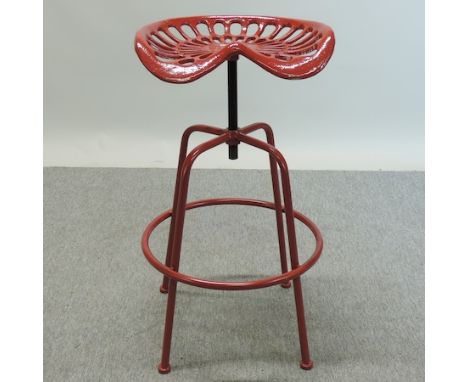 A red painted tractor seat bar stool