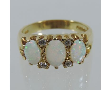 An 18 carat gold three stone opal and diamond ring, boxed