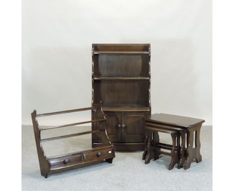 An Ercol elm desk, together with a waterfall bookcase, 163cm, a wall shelf and nest of three tables (4)