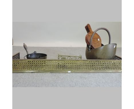 A pierced brass fender, 120cm, together with a coal scuttle and fire tools