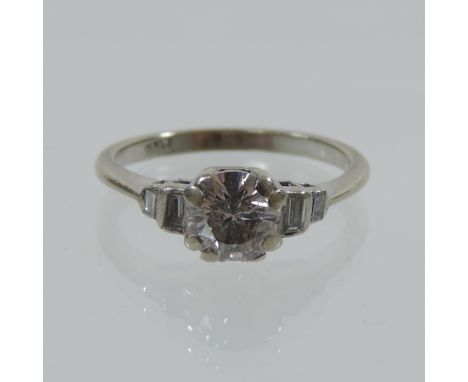 An 18 carat gold single stone diamond ring, approximately 3/4 carat, with baguette cut diamond shoulders, boxed, with a valua