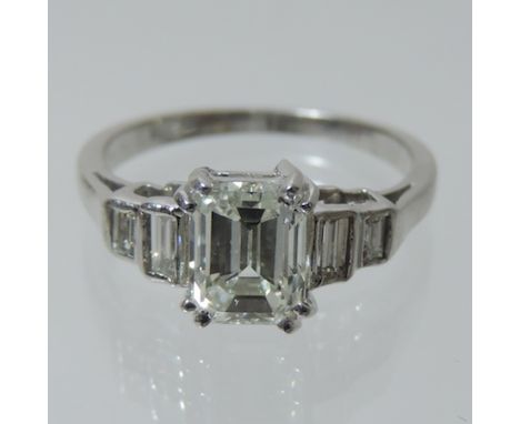 An 18 carat white gold five stone diamond ring, the central emerald cut stone approximately 1.5 carat, with stepped shoulders