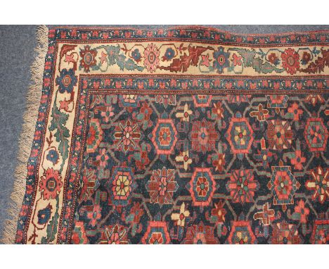 A Persian runner carpet with all-over geometric floral design, 435cm by 106cm