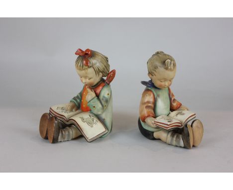 Two Goebel Hummel figures of a boy and girl reading, modelled as bookends, together with a Hummel poetry picture book, 15cm h