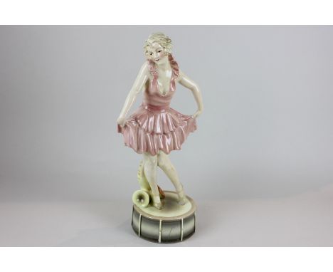 A Goldscheider porcelain figure of a girl dancing on a drum in a pink dress with a saxophone (a/f - heavily restored), 36cm h