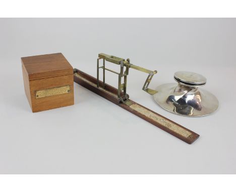 A George V silver inkwell (a/f), a  portable coin scale by Wilkinson and a wooden cased inkwell made from the teak of HMS Iro