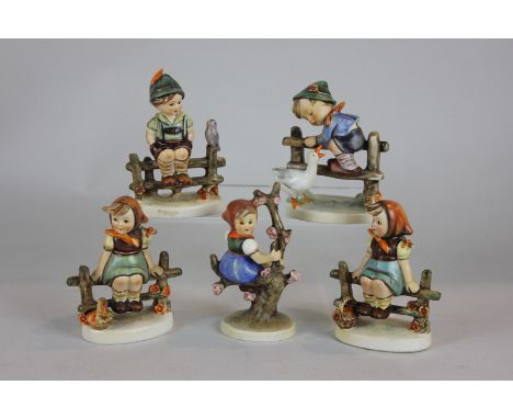 Five Goebel Hummel figures of children climbing fences and trees, tallest 12cm